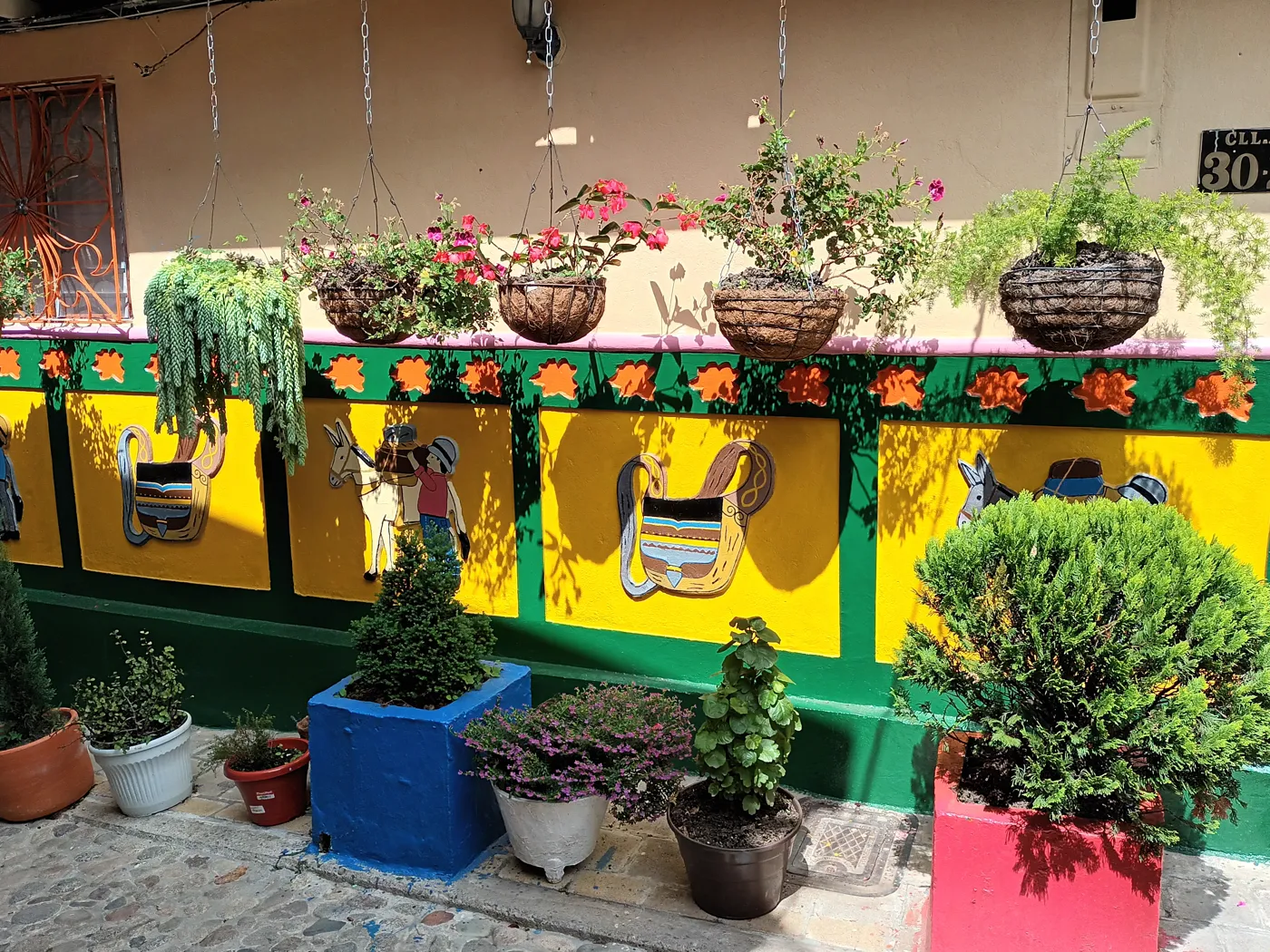 Calle de Guatapé con balcones, matas y zócalos de colores