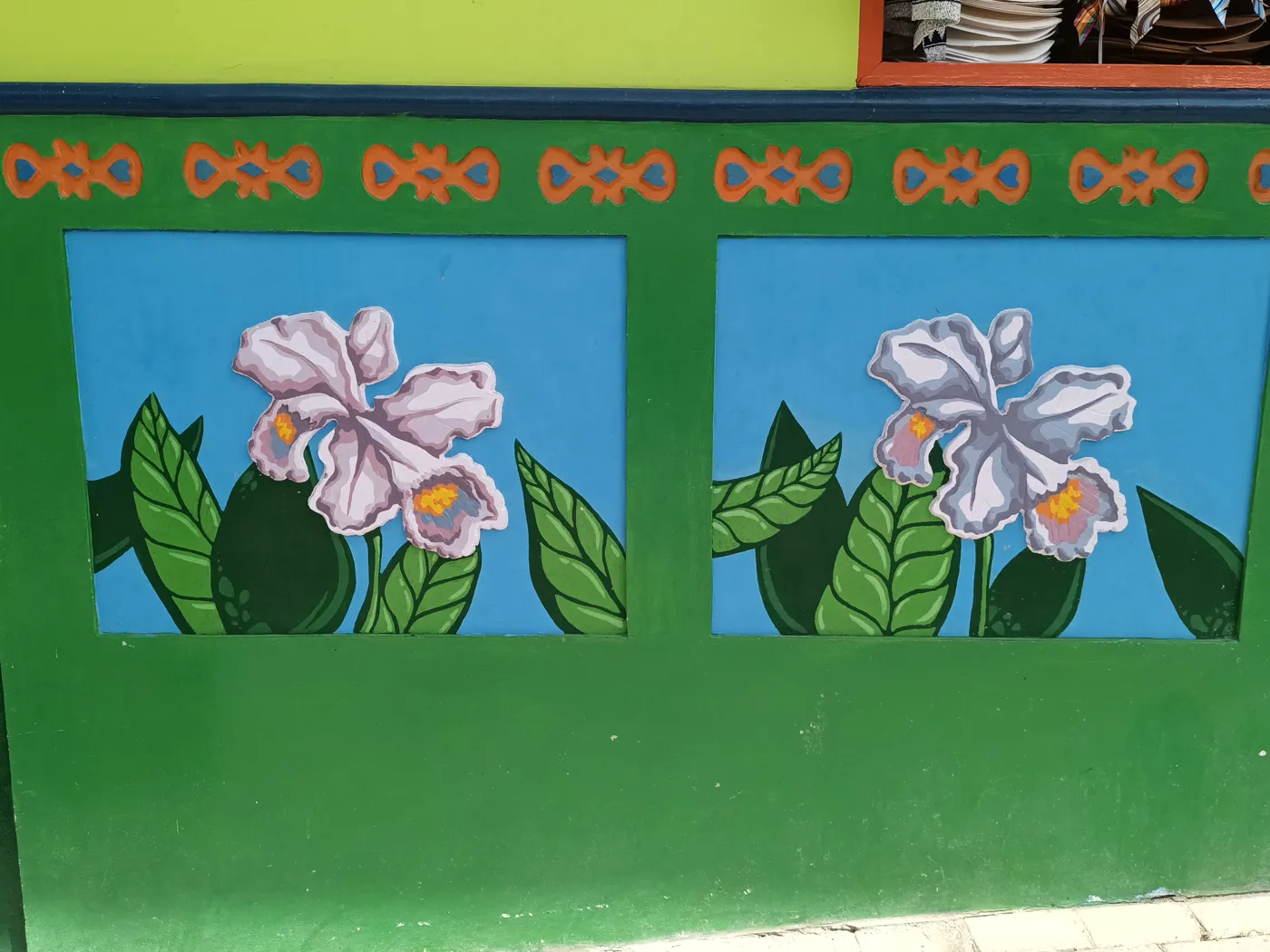 Zócalos de Guatapé pintados de verde con flores en relieve