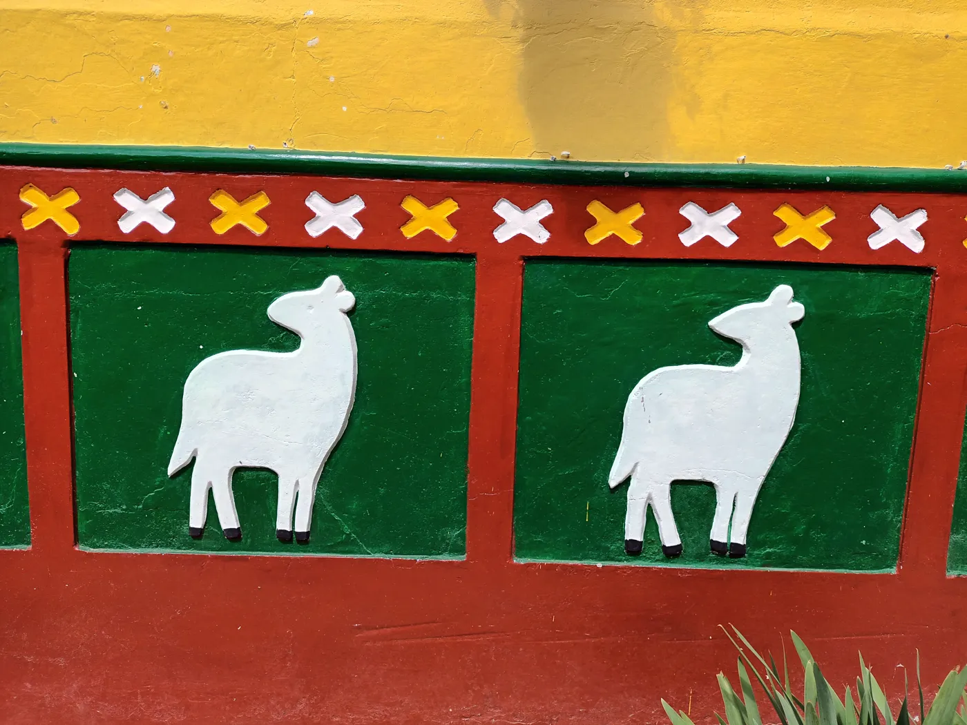 Zócalo rojo y verde con dos ovejas blancas en relieve